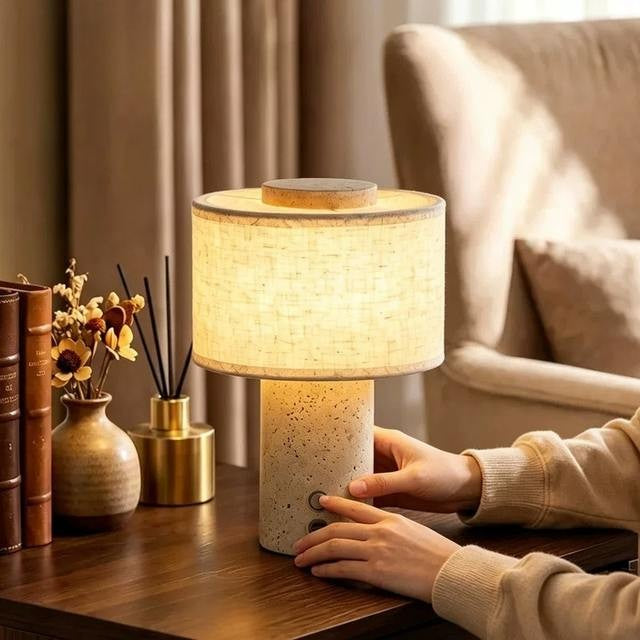 Duna travertine cordless lamp lit on a side table in a living room