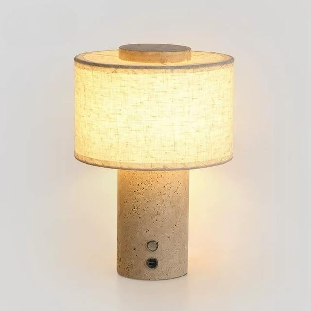 Duna travertine cordless table lamp with linen drum shade on a plain background