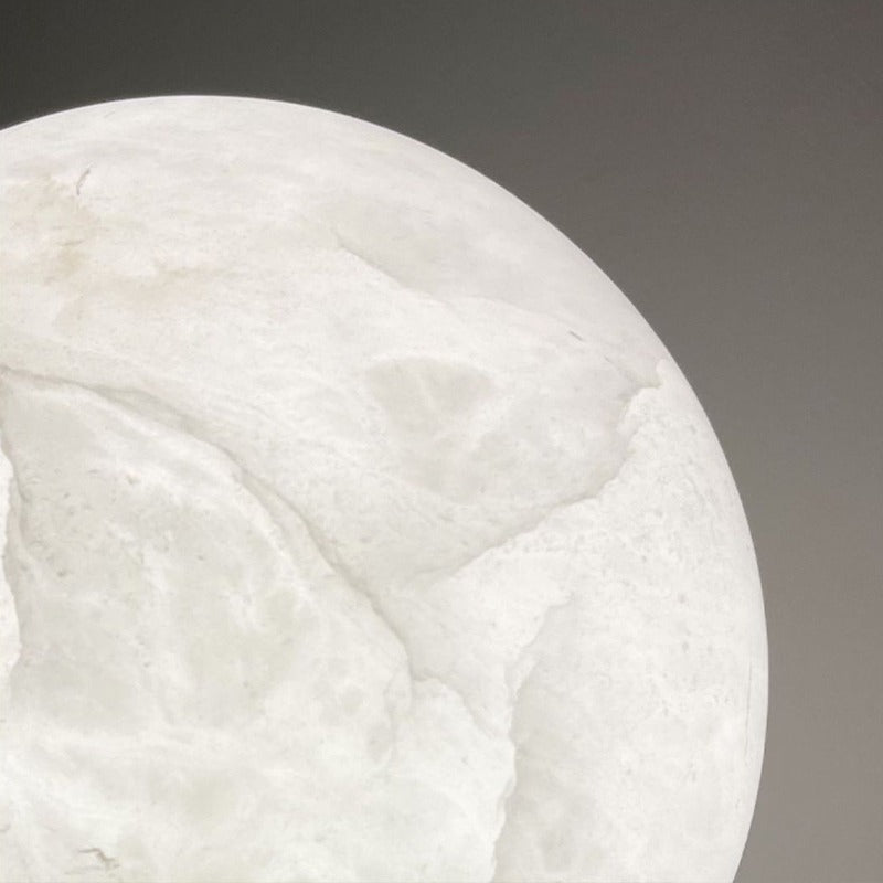 Close-up of the Luna's white natural alabaster lit from inside, showing soft grey cloud-like veining